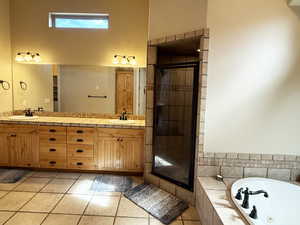 Bathroom with a whirlpool tub, light tile patterned flooring, double vanity, and a shower stall