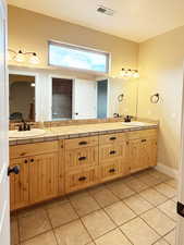 Ensuite bathroom featuring light tile patterned flooring and double vanity