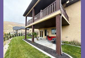 Back of house with a patio, a mountain view, french doors, and stucco siding