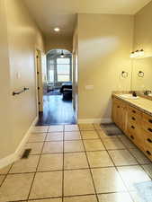 Bathroom with double vanity, light tile patterned floors, ceiling fan, recessed lighting, and ensuite bathroom
