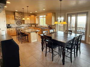 Dining space with light tile patterned floors and recessed lighting