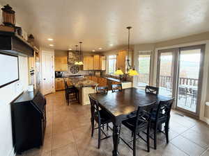 Dining area with light tile patterned flooring, recessed lighting, and a textured ceiling