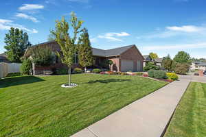 Ranch-style house featuring brick siding, a garage, and sidewalk