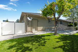 Back of house featuring stucco siding, a patio, a gate, and entry steps