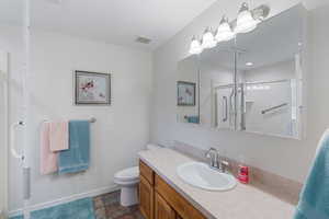 Ensuite Primary bathroom featuring vanity, dark stone finish floors, and a shower stall
