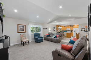 Great Room featuring vaulted ceiling, light carpet, recessed lighting, and a chandelier