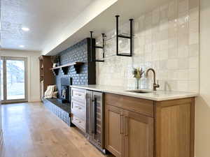 Bar area with beverage cooler, quartz countertops, and custom cabinetry