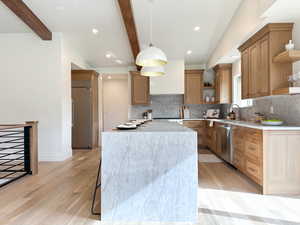 Kitchen with custom cabinetry, quartz countertops, breakfast bar, new appliances, mountain views, and a door out to the deck.