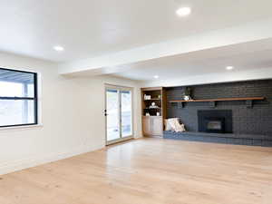 Lower Level family room featuring a wood stove, custom built-ins, daylight windows, and walkout basement