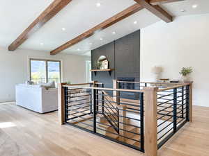 Great Room with vaulted ceilings, hardwood floors, custom railing, and fireplace