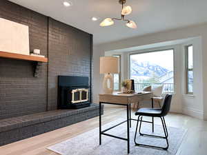 Office/Flex space with light wood-style floors, a wood stove, and recessed lighting