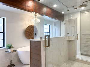 Primary bathroom featuring steam shower with double entry and soaking tub