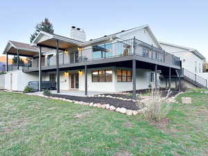 Rear view of property featuring a large deck deck and patio