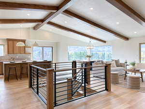 Great Room with vaulted ceilings, hardwood floors, custom railing, and custom kitchen.