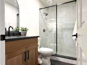 3/4 bathroom with vanity, dark tile patterned flooring, shower, and mosaic tile