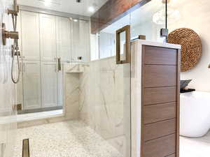 Full bath featuring a marble finish shower