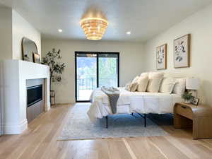 Primary bedroom featuring a fireplace, mountain views, and a sliding door out to the covered deck