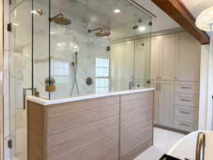 Primary bathroom with steam shower featuring double shower head and custom tile