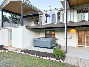 Back of property featuring a hot tub and  entry into the spa