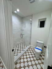 Bathroom with a shower stall and recessed lighting