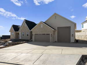 View of front of property with brick siding, a garage, and concrete driveway