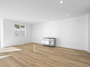 Kitchen with light wood-type flooring and recessed lighting. Cabinets and island coming soon!