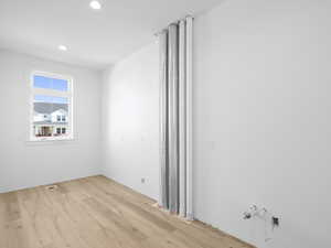 Laundry room with light wood-style flooring and recessed lighting. Finishes coming soon!