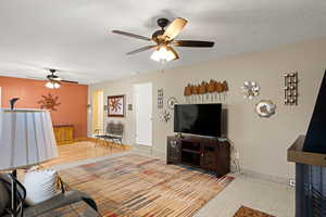 Living room with a textured ceiling and a ceiling fan