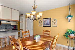 Dining area with light wood finished floors and a chandelier