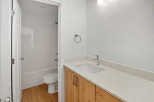 Bathroom featuring vanity, light wood-style floors, and shower / tub combination