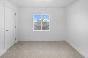 Unfurnished bedroom featuring light colored carpet and baseboards