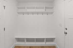 Mudroom with light wood-style flooring and baseboards