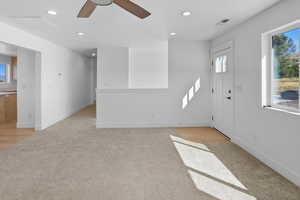 Foyer entrance with recessed lighting, light carpet, and a ceiling fan