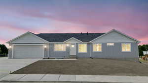 Ranch-style house featuring driveway, a garage, and board and batten siding