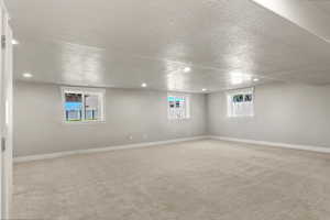 Basement featuring light colored carpet, recessed lighting, and a textured ceiling