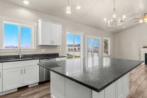 Kitchen featuring white cabinets, a center island, light wood-style floors, stainless steel dishwasher, and recessed lighting