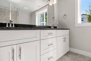 Full bath featuring double vanity and a stall shower