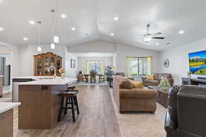 Living room with dark wood-style flooring, lofted ceiling, recessed lighting, a chandelier, and ceiling fan