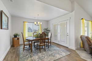 Dining room featuring light wood-style flooring and a chandelier