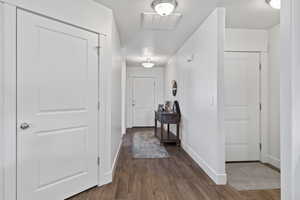 Hallway with dark wood-style flooring and baseboards