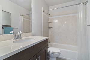 Bathroom featuring shower / bath combo with shower curtain and vanity