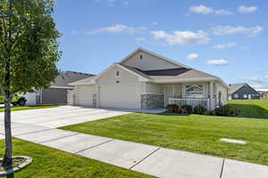 View of front of property with stucco siding, a garage, and a front lawn