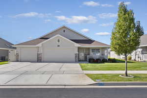 View of front of property with a garage, concrete driveway, a front lawn, stucco siding, and a porch