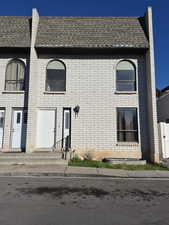 French country inspired facade featuring brick siding and roof with shingles