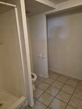 Full bathroom with light tile patterned floors and a stall shower