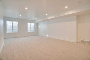 Empty room with recessed lighting and light carpet