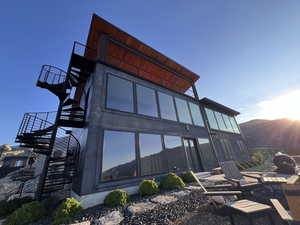 View of property exterior featuring stairs and a fire pit