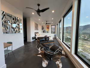 Living room with a ceiling fan, recessed lighting, and concrete floors