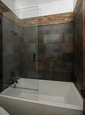 Bathroom featuring bath / shower combo with glass door