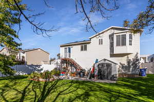 Back of property featuring a storage shed, stairs, and a patio area